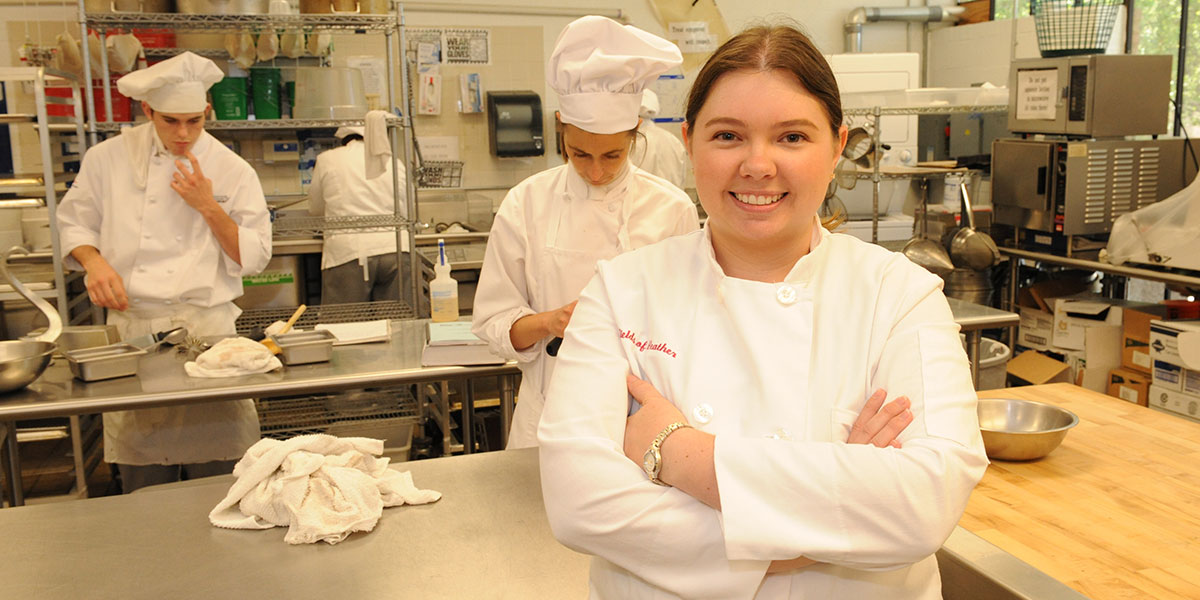 Alumna Heather Howe standing in her bakery kitchen.