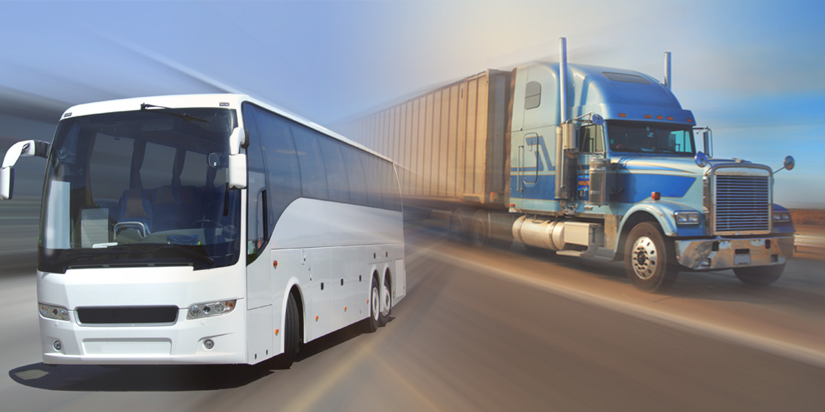 A motor coach and tractor trailer on the highway.