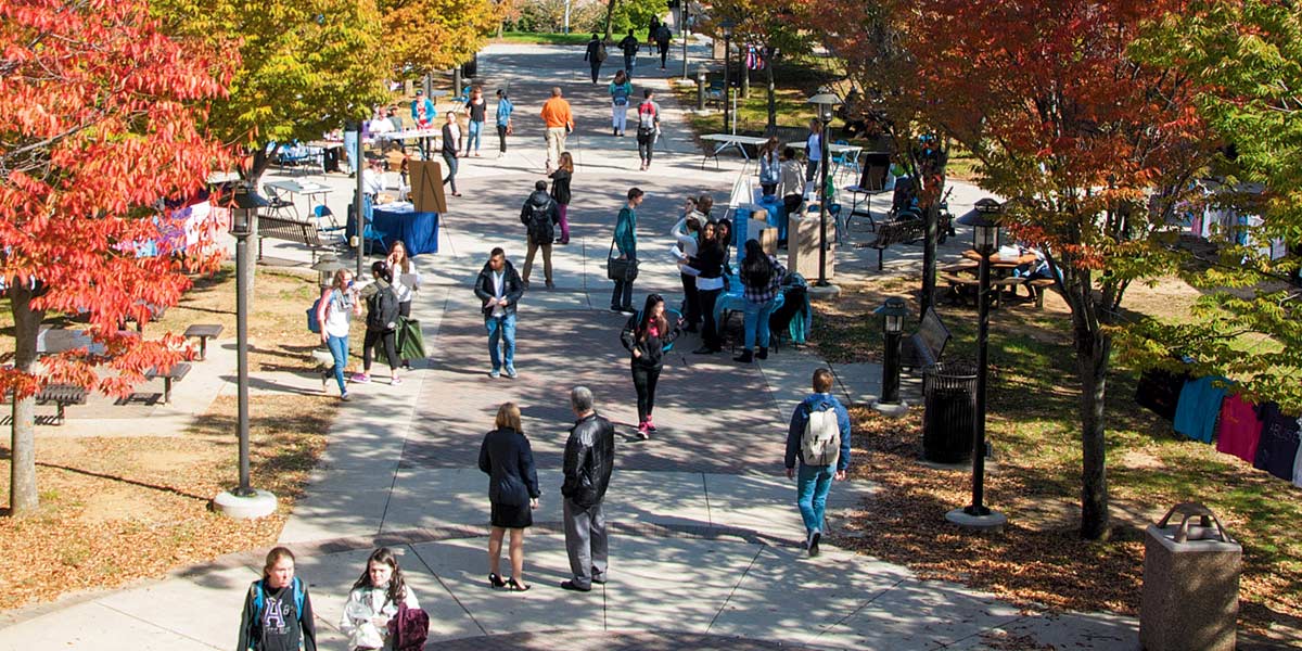 Students walk across the quad in autumn.