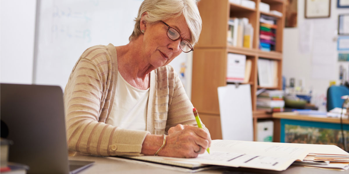 Senior student writing at desk