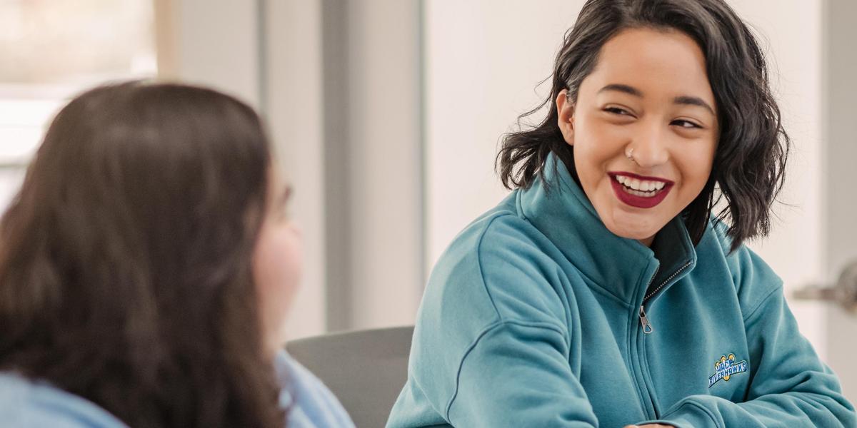 Student smiling and looking at other student.